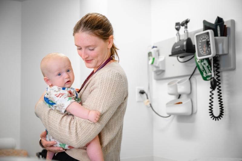 a healthcare provider holding a baby