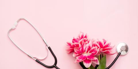 a stethoscope and flowers on a pink background